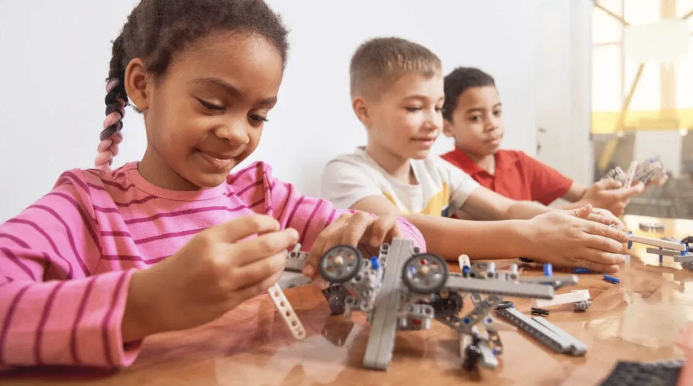 Elementary school students work with hands-on building activities.